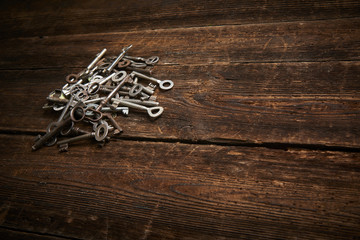 A Pile of Antique Keys on a weathered wooden background
