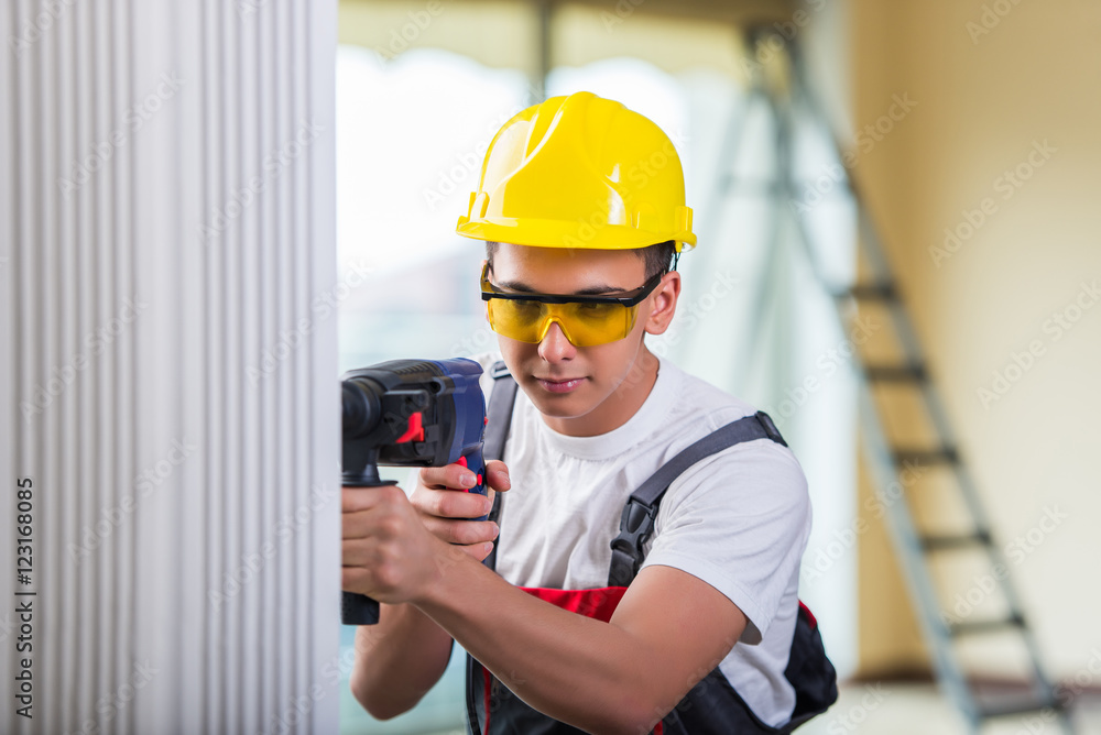 Wall mural man drilling the wall with drill perforator