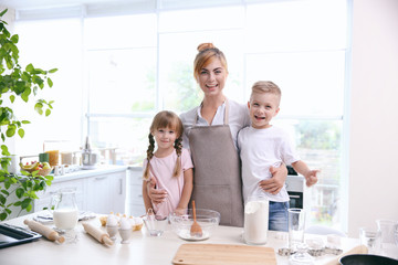 Fototapeta na wymiar Mother and kids making dough in kitchen