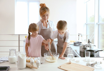 Obraz na płótnie Canvas Mother and kids making dough in kitchen