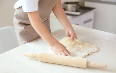 Child with rolling pin and dough, closeup