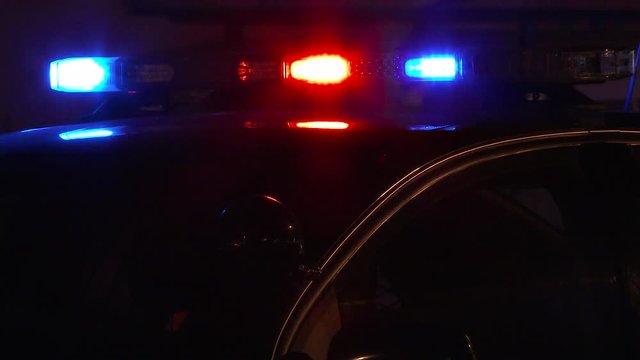 Police lights flashing close up at night at crime scene.