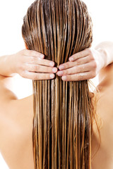 Woman applying hair conditioner. Isolated on white.