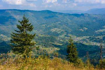 Top of the hill in Carpathian's. View to the village in mountains. Beautiful blue sky with clouds in the background. Summer time.