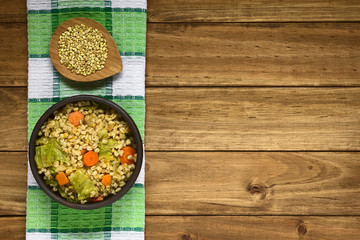 Veganischer Eintopf aus gekochtem Weizen, Wirsing, Kürbis und Karotte serviert in rustikale Schüssel, fotografiert mit natürlichem Licht