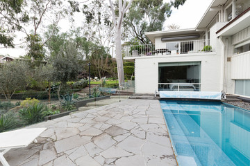 crazy paving beside swimming pool in mid century modern home