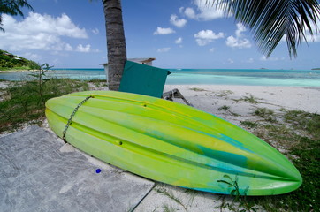 Green plastic canoe drying at Cocobay beach