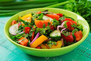 Fresh salad of tomatoes, cucumbers, peppers, arugula and red onion