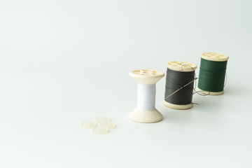 Close up of sewing items,Spool of thread, needle and button isolated on white background