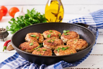 Juicy delicious meat cutlets in pan on a wooden table.