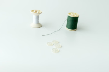 Close up of sewing items,Spool of thread, needle and button isolated on white background