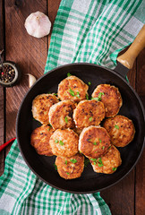 Juicy delicious meat cutlets in pan on a wooden table. Top view