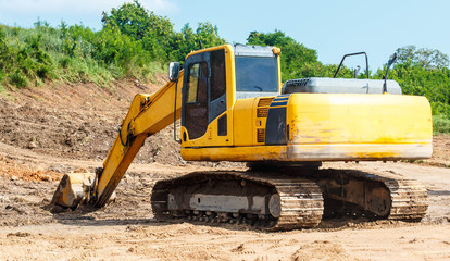Yellow digger working on a road construction in mountain