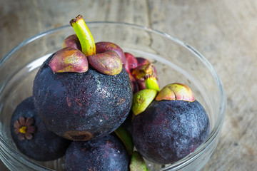 Mangosteen and cross section showing the thick purple skin and w