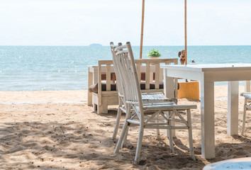 white chairs and table on beach with a view of blue ocean and cl