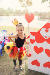 cute girl with handmade red heart card with  Alice in wonderland party