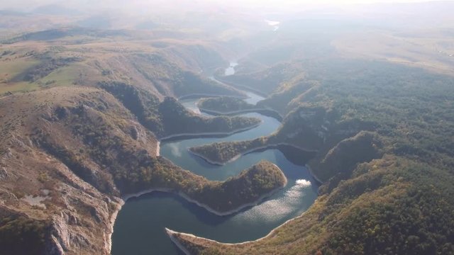 Aerial view on beautiful mountain river surrounded with autumn forest and mountains.
