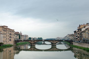 Florence, Ponte alla Carraia medieval Bridge landmark on Arno river, sunset landscape with reflection. Tuscany, Italy. Popular touristic view, travel destination.