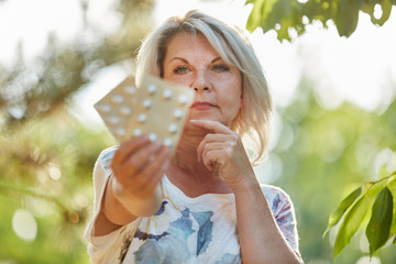 Alte Frau mit Medikamenten in der Hand