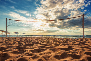 Volleyball net and sunrise on the beach