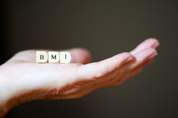 BMI, Bodymaßindex, Idealgewicht, Würfel auf der Hand, symbolisch