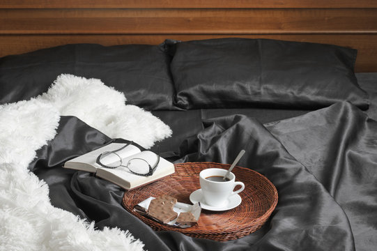 Coffee with chocolate and book in bed