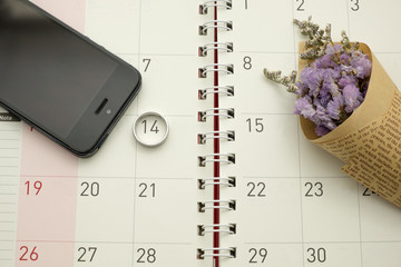circle date in calender with purple flower and mobile phone on calendar background