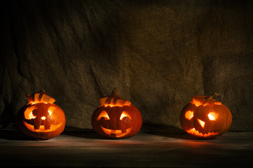 Halloween pumpkin head jack lantern on burlap background