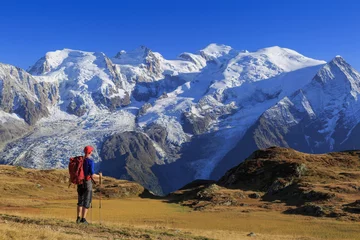 Fototapete Mont Blanc Wanderer auf einer Wiese mit Blick auf den Mont Blanc, während seiner Wanderung der Tour du Mont Blanc.