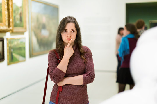 Closeup on attentive woman visiting museum and enjoying sculture