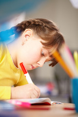 A little schoolgirl absorbed in drawing