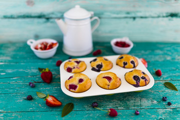 Delicious homemade pastries, muffins with berries on wooden table. 