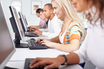 Fototapeta premium Selective focus of a girl working with computer among other students