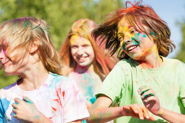 Fototapeta premium Cute kids smeared with colored powder on Holi fest