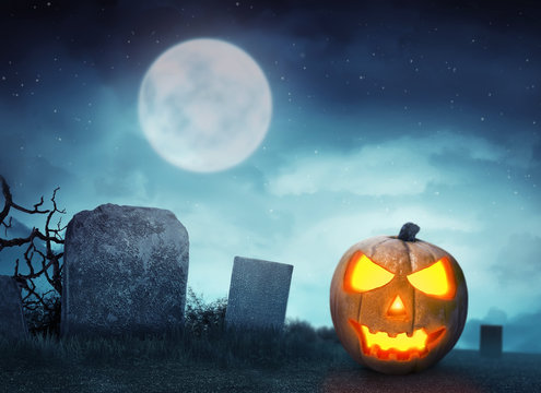 Spooky cemetery with glow halloween pumpkin