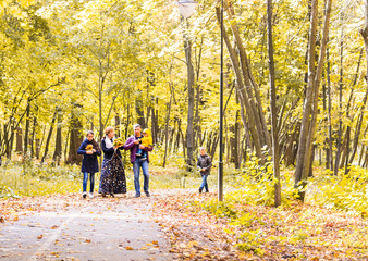 Fototapeta premium Happy young family spending time together outside in autumn nature.
