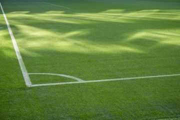 Fototapeta premium Football soccer field corner with white marks, green grass texture.