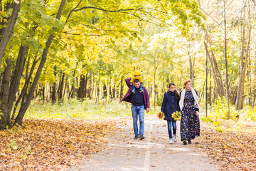 Obraz premium Happy young family spending time together outside in autumn nature.