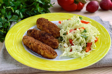 Meat cutlet with a salad of cabbage, peppers and herbs.