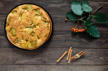 Home baked biscuit flavored pear charlotte cake with cinnamon. On a dark wooden background. The top view.