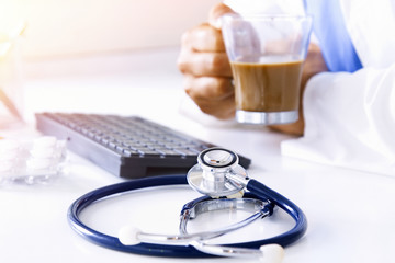 stethoscope with doctor's hands and coffee