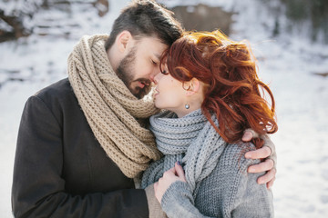 Stylish young beautiful couple embracing. Background winter moun