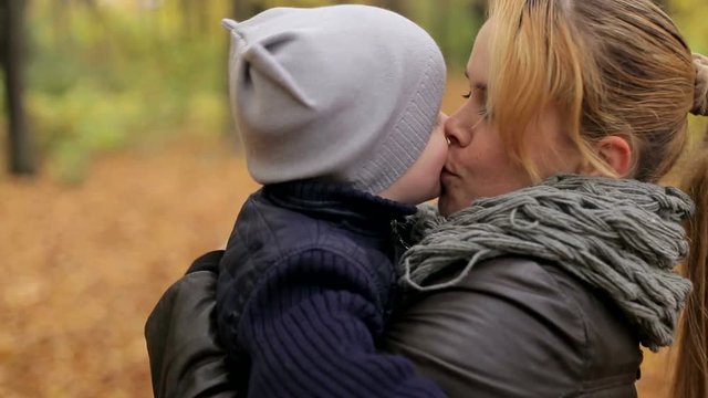 Cute little boy hugs and kisses his mother.