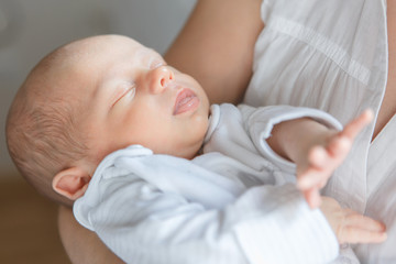 Newborn baby boy asleep in mother's arms

