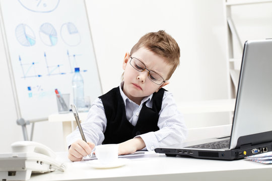 Little boy absorbed in office work 