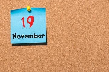 November 19th. Day 19 of month, color sticker calendar on notice board. Autumn time. Empty space...