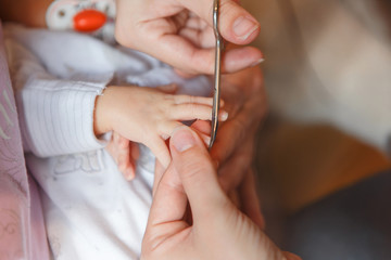 Obraz na płótnie Canvas Сutting newborn baby nails with scissors 