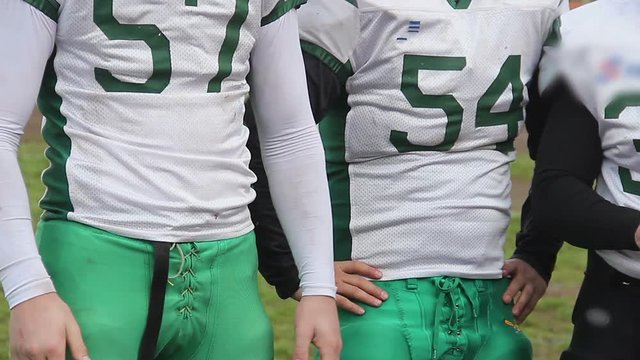 Football players applauding to support teammates entering or leaving field