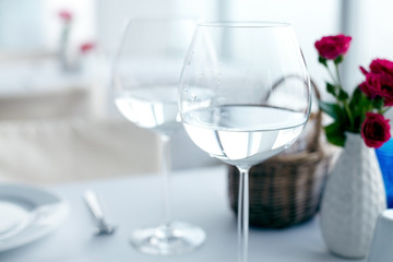 Close-up of elegant wine glasses with water on table 