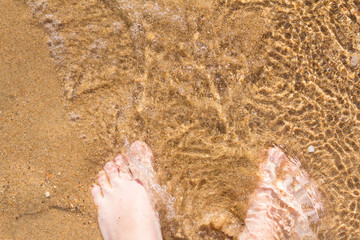 Feet on sand and sea. Summer mood.